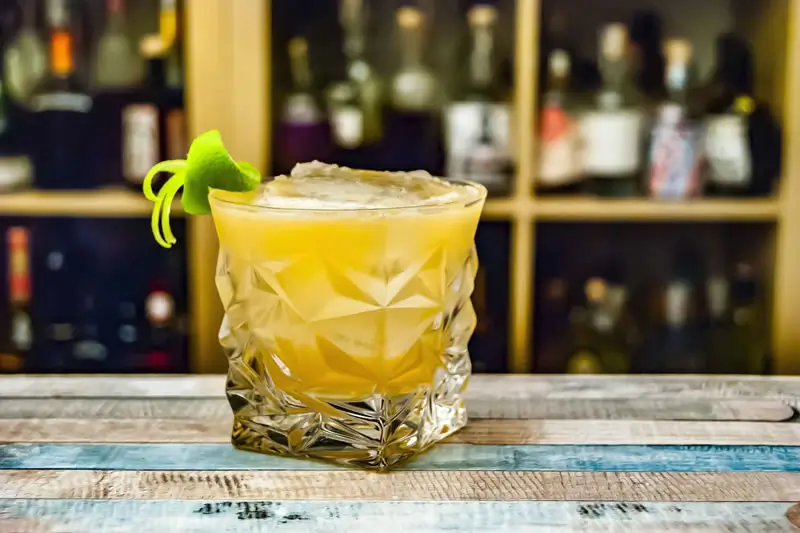 Cóctel de Whisky Sour en vaso corto decorado con limón