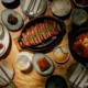 Prime ribeye estilo Barbecue Coreano, bulgogi, shishitos, banchan, lechuga, jangachi, sopa de kimchi con mariscos, arroz