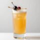 Vaso de amaretto sour con cerezas