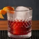 Vaso con cóctel Negroni servido con hielo y rodaja de naranja