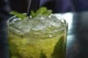 Prepara un Mojito Caballito Vaso de el cóctel Mojito Caballito con hielos y hojas de menta