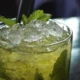 Vaso de el cóctel Mojito Caballito con hielos y hojas de menta