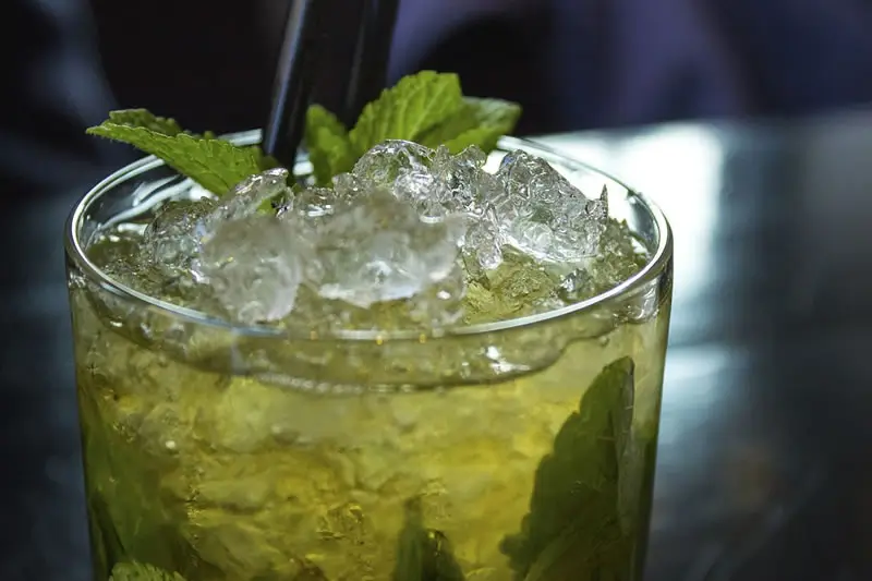 Vaso de el cóctel Mojito Caballito con hielos y hojas de menta