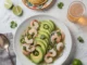 Aguachile de Camarón: El Clásico Picante y Fresco de la Cocina Mexicana Tazón de aguachile de camarón con un plato de tostadas y vaso de cerveza