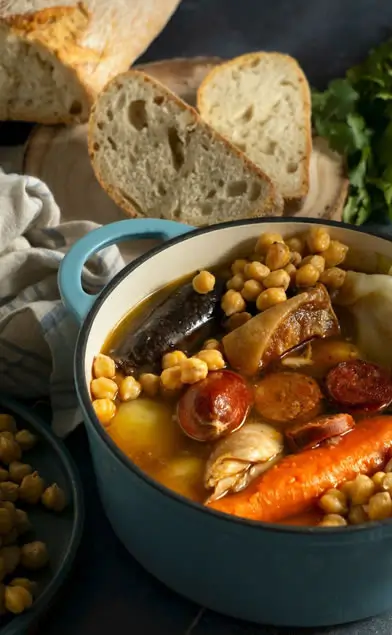 Cocido Madrileño: Historia, Ingredientes y Cómo Prepararlo Paso a Paso Cocido madrileño con una hogaza de pan