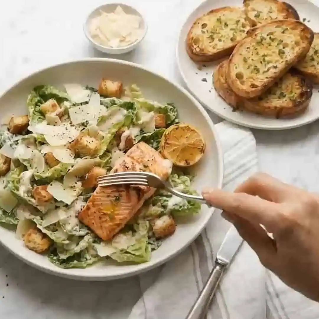 Ensalada César Con Salmón y Pan Con Ajo: un Clásico Renovado Con Mucho Sabor Platón de salmón con ensalada césar