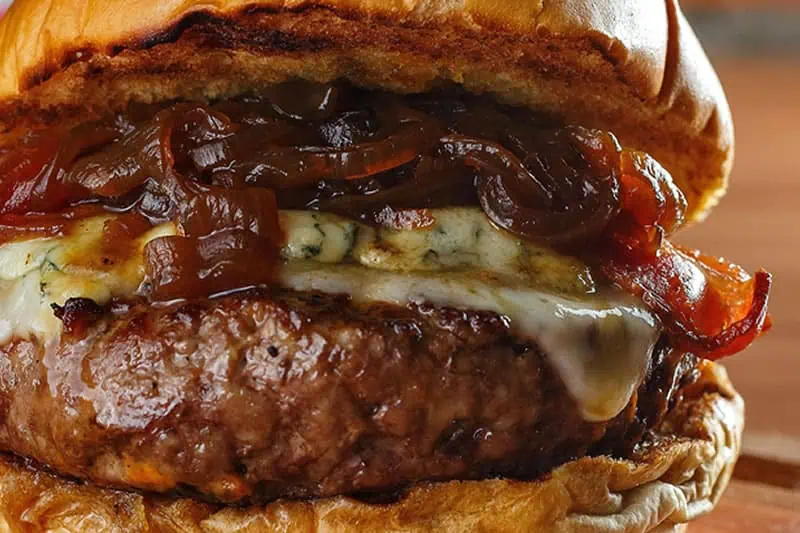 Imagen preparando una hamburguesa con cebolla caramelizada