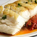 Pescado blanco servido con tomates deshidratados