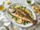 Lobina al Horno: Un Plato Elegante, Saludable y Lleno de Sabor Plato con una lobina al horno
