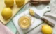 Lemon Curd Casero (Crema de Limón) Lemon curd casero servido en un frasco de vidrio con limones frescos y ralladura de limón sobre una superficie de mármol blanco.