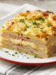 Pastel de papa con jamón cocido y queso fundido recién horneado con superficie gratinada y porción servida.