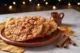 Buñuelos crujientes con miel de piloncillo y canela servidos en un plato de barro