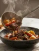 Plato hondo de estofado de res casero con papas, zanahorias y perejil fresco