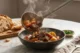 Estofado de Res Casero: el guiso que huele a hogar Plato hondo de estofado de res casero con papas, zanahorias y perejil fresco