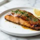 Salmón Glaseado Con Miel y Ajo: la cena de 25 minutos que siempre luce como de restaurante Filete de salmón glaseado con miel y ajo, con perejil y ajonjolí, sobre una superficie de mármol blanco
